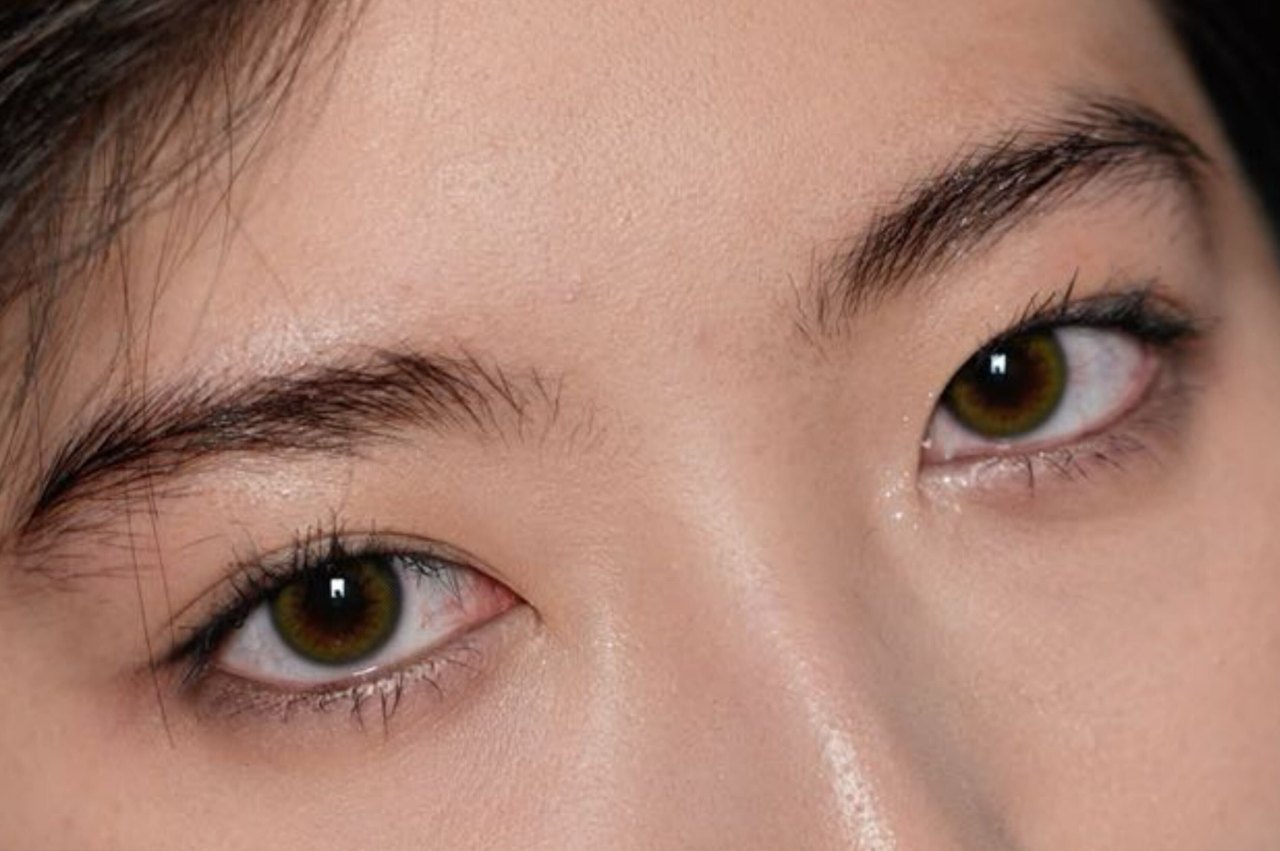 A third client before any work, photographed straight on: fine natural brows, sparse through the body and fading out well before the tail.